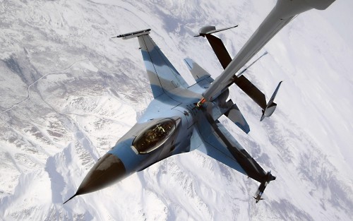 An F-16 Fighting Falcon showing the aggressor paint scheme disconnects from a KC-10 Extender after b