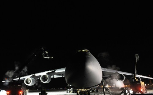 Two de-icer vehicles work on a C-5M Super Galaxy after the aircraft sat outside for more than 24 hou