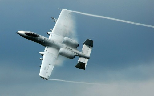 An A-10 Thunderbolt II ground attack aircraft pulls up sharply out of a low-level strafing run durin
